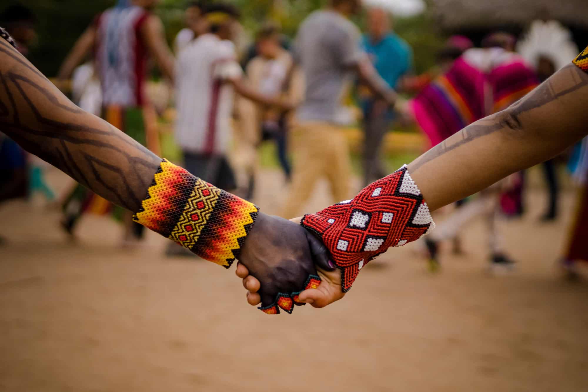 Sao Paulo, SP, Brazil - April 20 2023: People holding hands wearing traditional colorful bracelets of indigenous peoples.
